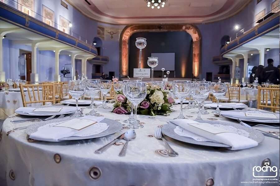 Detalle de decoración de mesas para invitados en boda campestre con vajilla premium y copas de cristal
