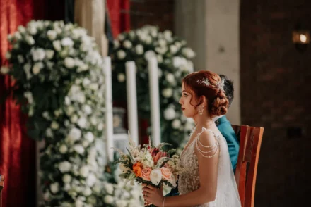 Novios en la iglesia con la decoración nupcial en el altar.
