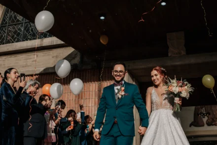Novios saliendo de la iglesia entre globos y aplausos