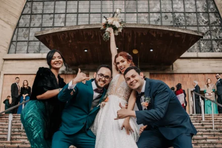 Novios celebrando su boda con amigos en una sesión de fotos alegre.