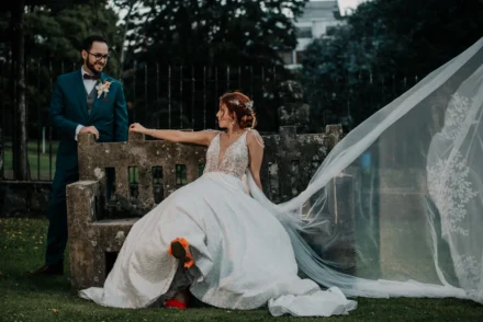 Novia posando con su vestido de boda en un jardín.