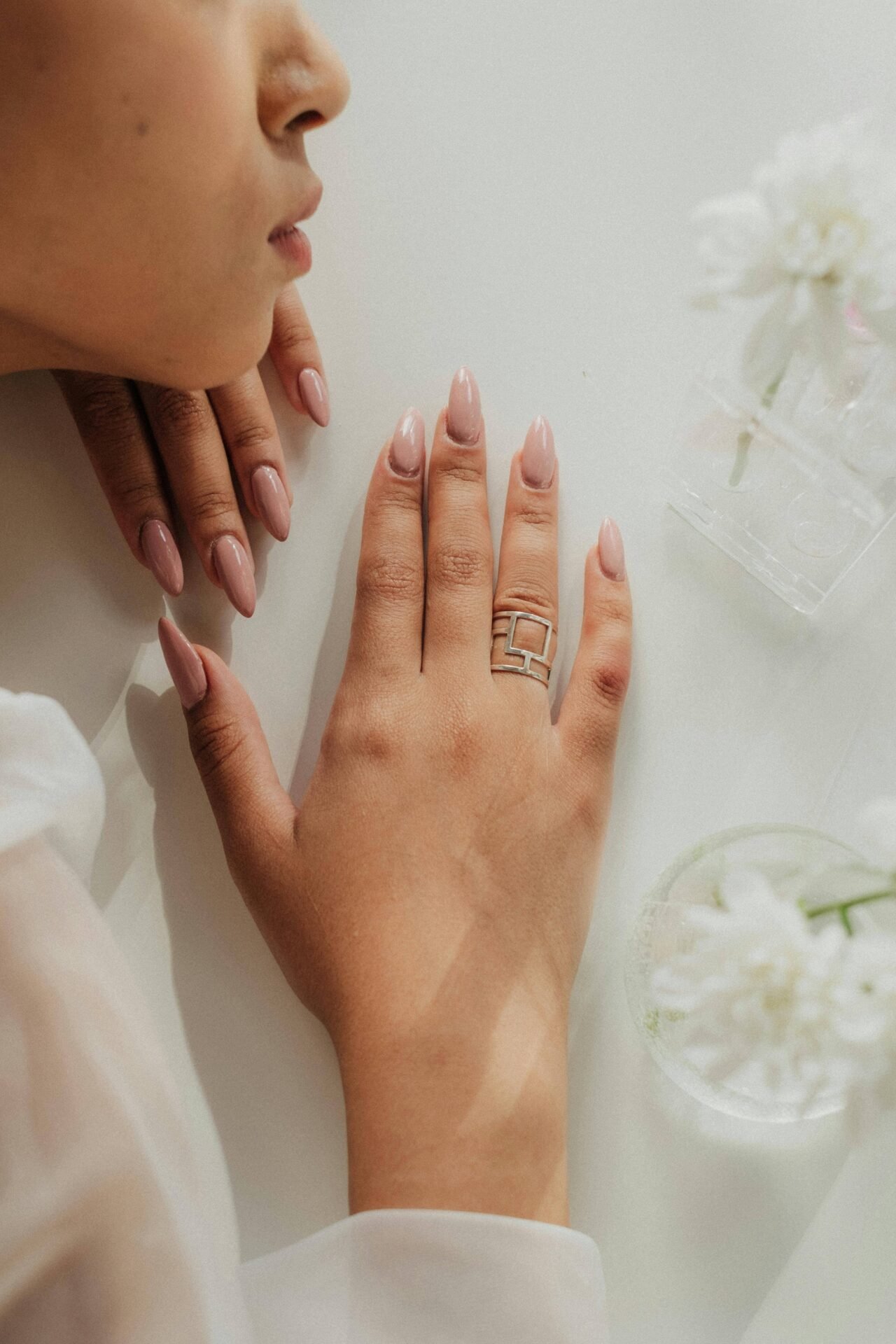Manicura-perfecta-para-lucir-anillo-de-compromiso. Uñas cortas y elegantes en un tono rosa Stiletto diseño de bodas pálido que hacen destacar el anillo de compromiso.