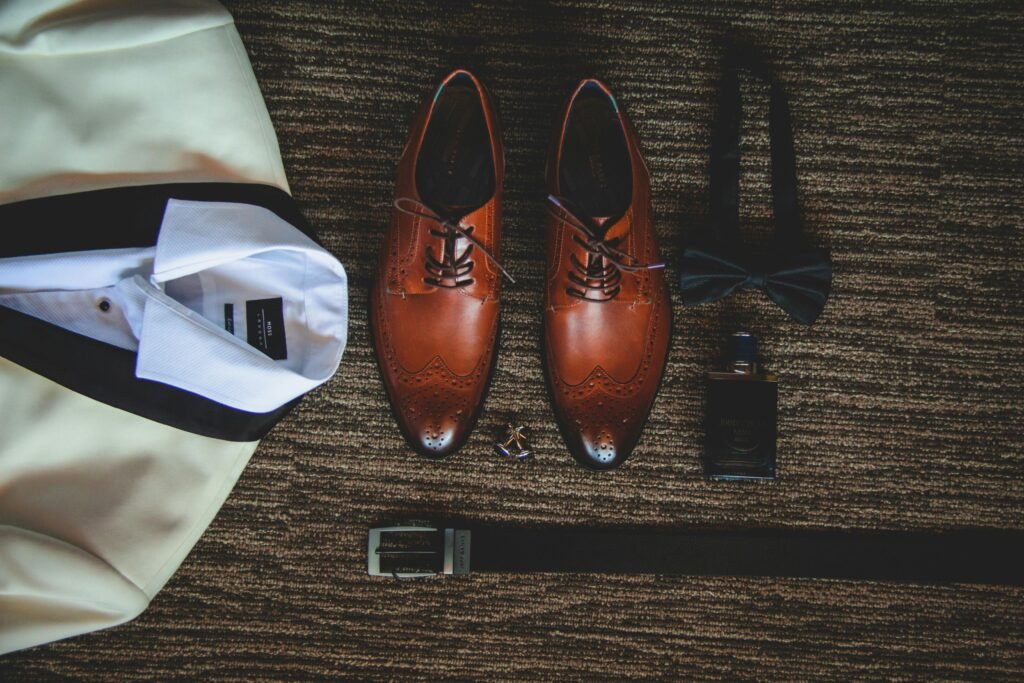 Zapatos de cuero marrón junto a un traje de novio