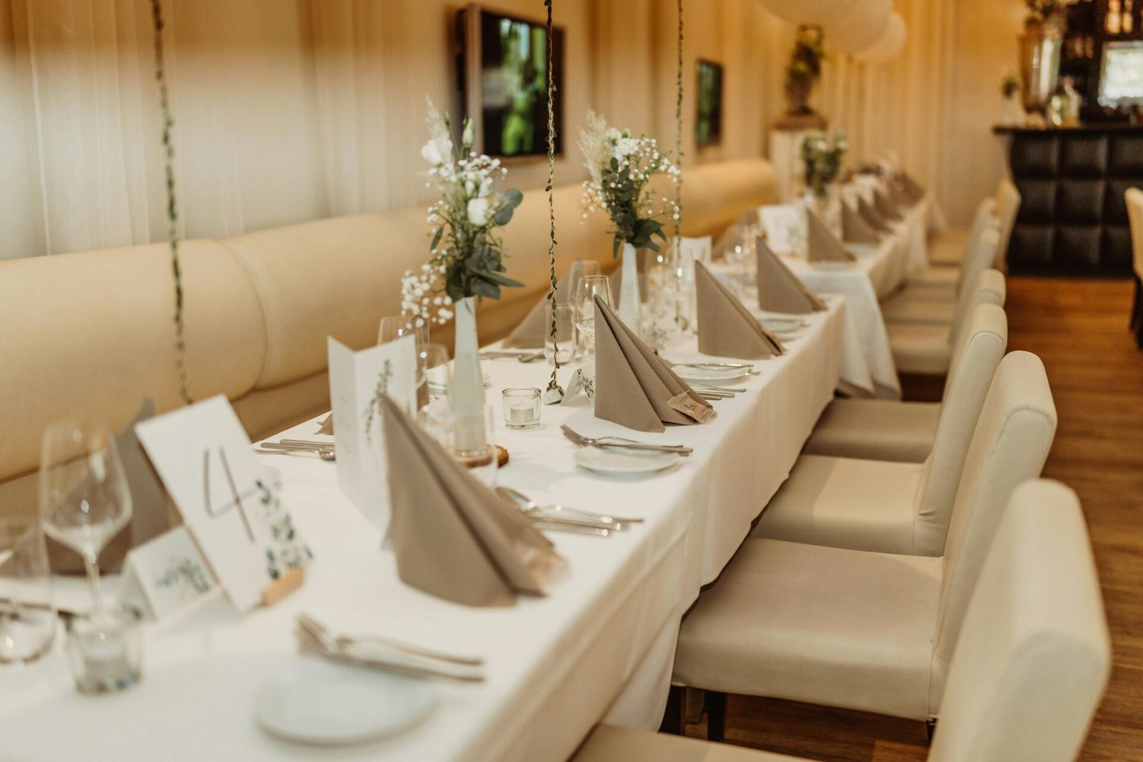 Mesa decorada elegantemente en un evento social, con platos, copas y flores sofisticadas.