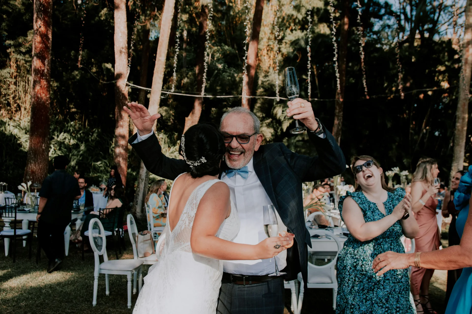Tradiciones de bodas colombianas: padre y novia bailando felices durante una boda al aire libre en Bogotá, Colombia.