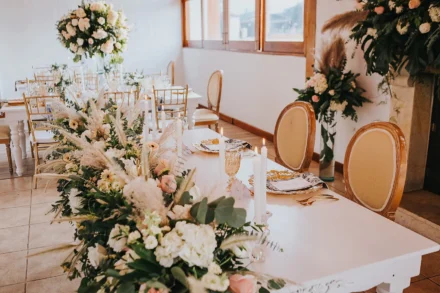 Centro de mesa con flores blancas y velas en boda