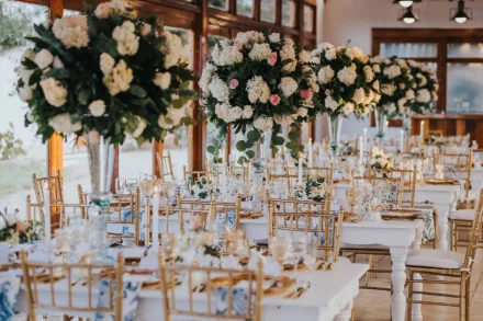 Decoración de boda con mesas elegantes en tonos blancos y dorado.