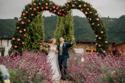 Novios bajo arco floral en boda campestre en Bogotá.