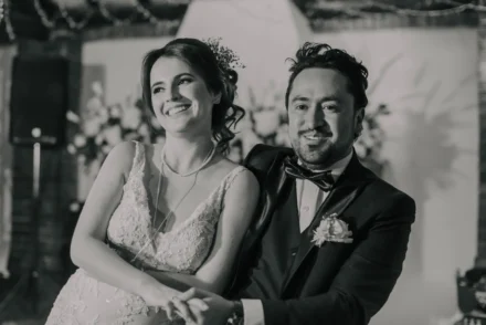 Pareja de recién casados bailando en un salón con lámparas de cristal.