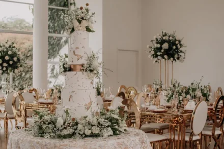 Pastel de bodas blanco con flores y detalles dorados