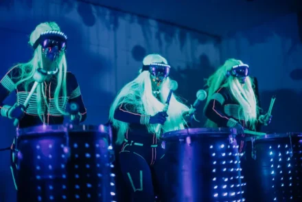 Show de percusión en vivo con artistas vestidos de neón