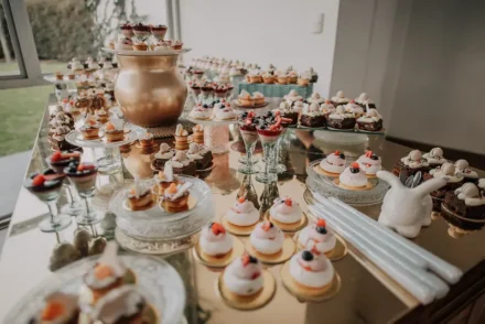 Mesa de postres con dulces elegantes y detalles dorados.
