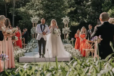 Pareja de novios brindando en una recepción de boda iluminada.