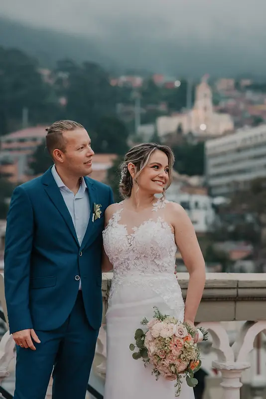 Novios posando con un paisaje montañoso detrás
