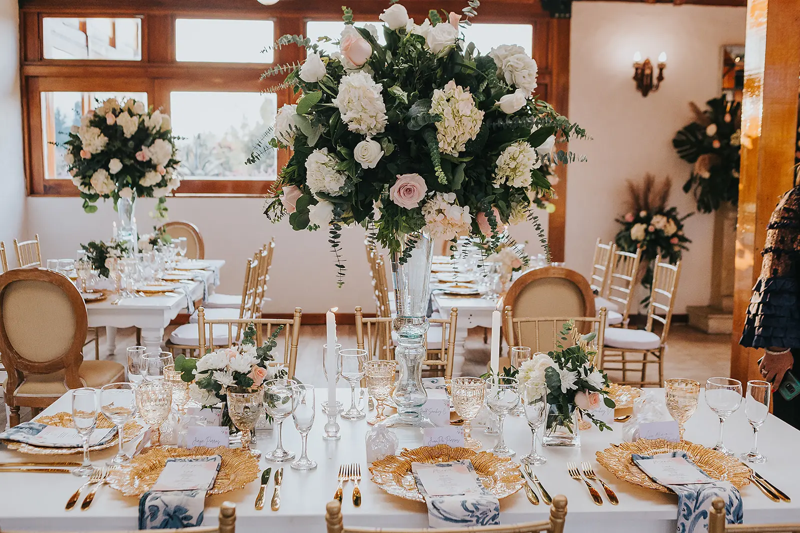 Centro de mesa con flores blancas y vajilla dorada en bodas cristianas en Bogotá