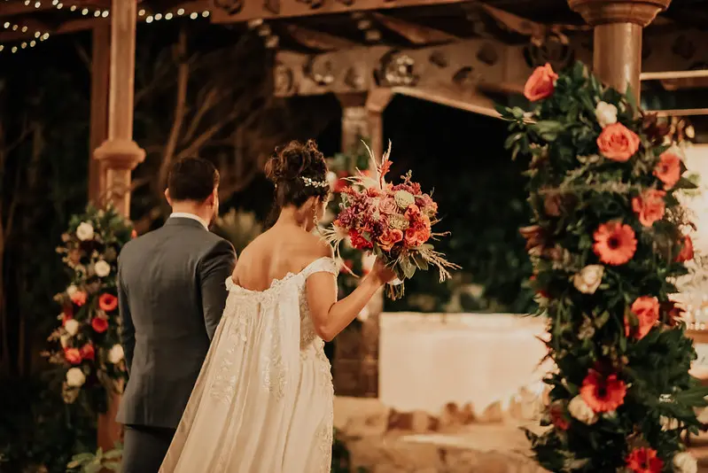 Novia sosteniendo ramo en ceremonia de boda campestre