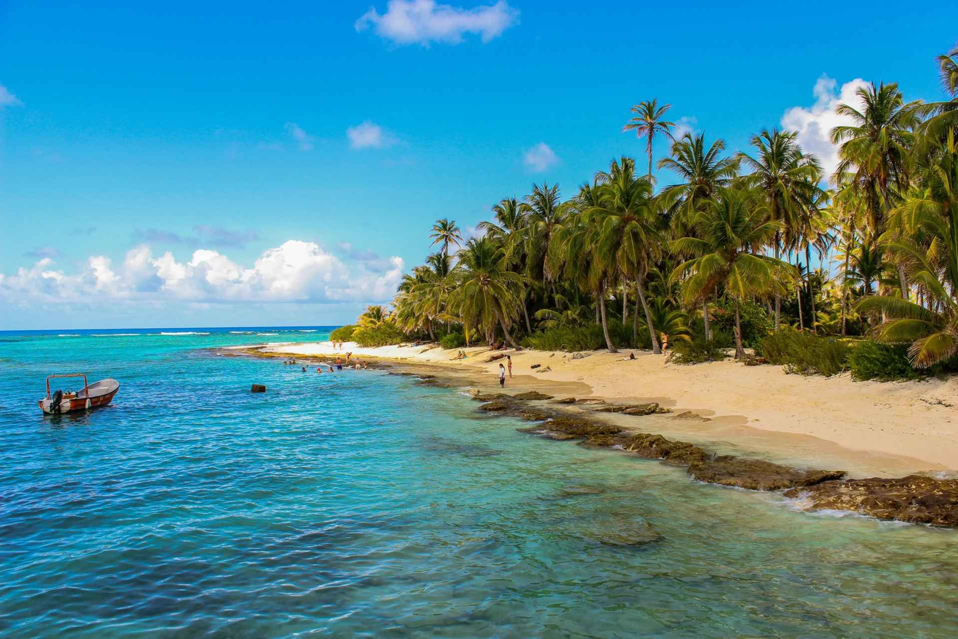 Vista de una playa paradisíaca con mar turquesa y palmeras, lugar perfecto para bodas en San Andrés.