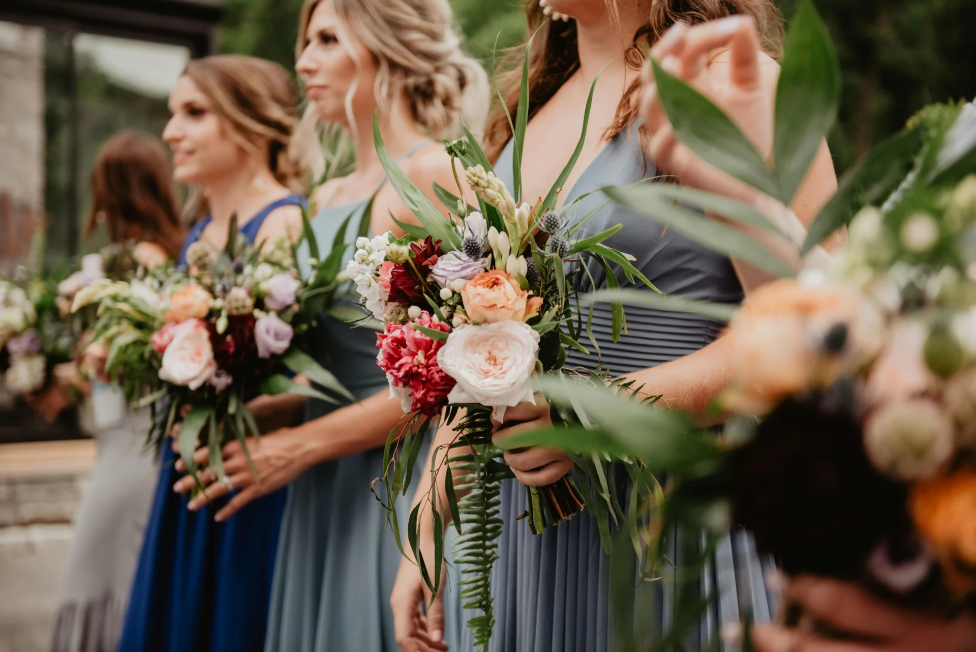Damas de honor elegantemente vestidas sosteniendo sus ramos de flores, parte esencial del protocolo de una boda en Colombia