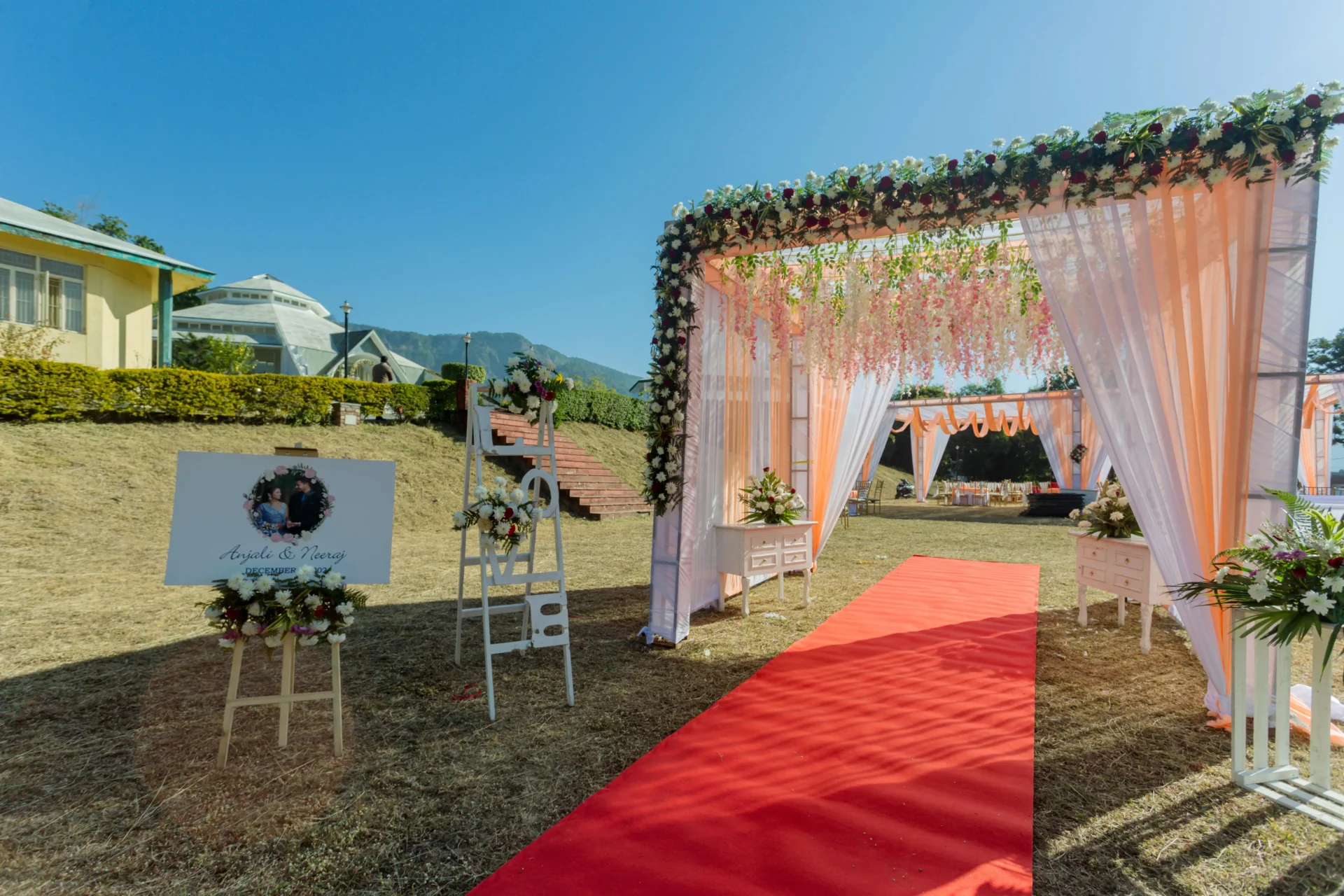 Altar decorado con cortinas rosadas y alfombra roja en la playa, preparado para una boda en San Andrés.