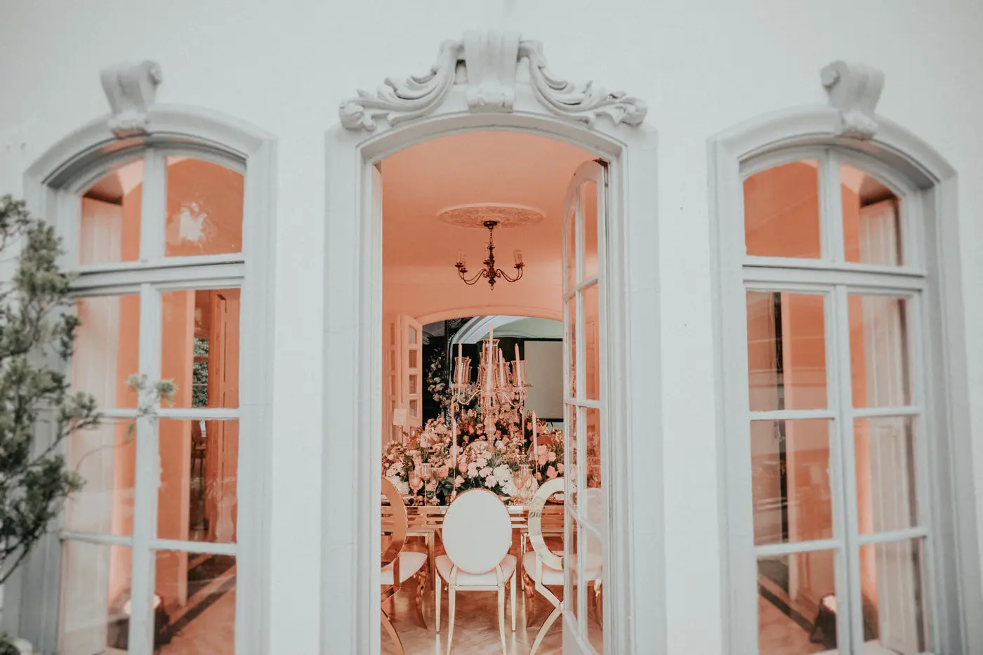 Vista del interior de una lujosa casa de eventos en Bogotá, mostrando a través de sus ventanales la decoración floral para una boda exclusiva.