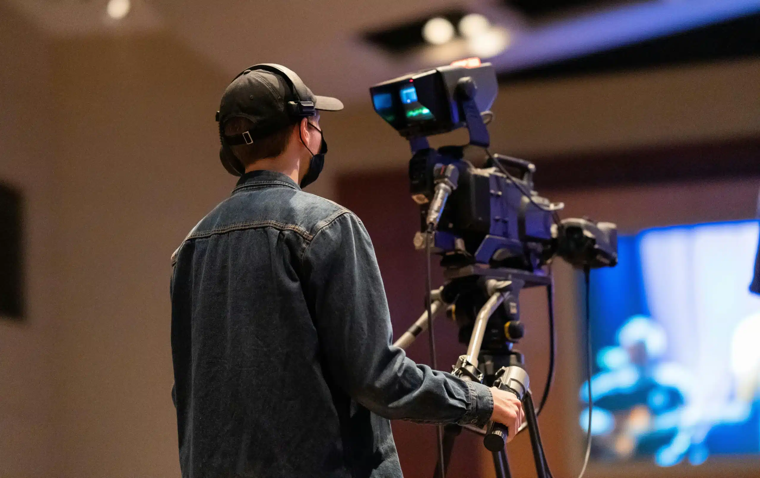 Producción audiovisual con pantallas y luces profesionales en un salón para eventos empresariales.