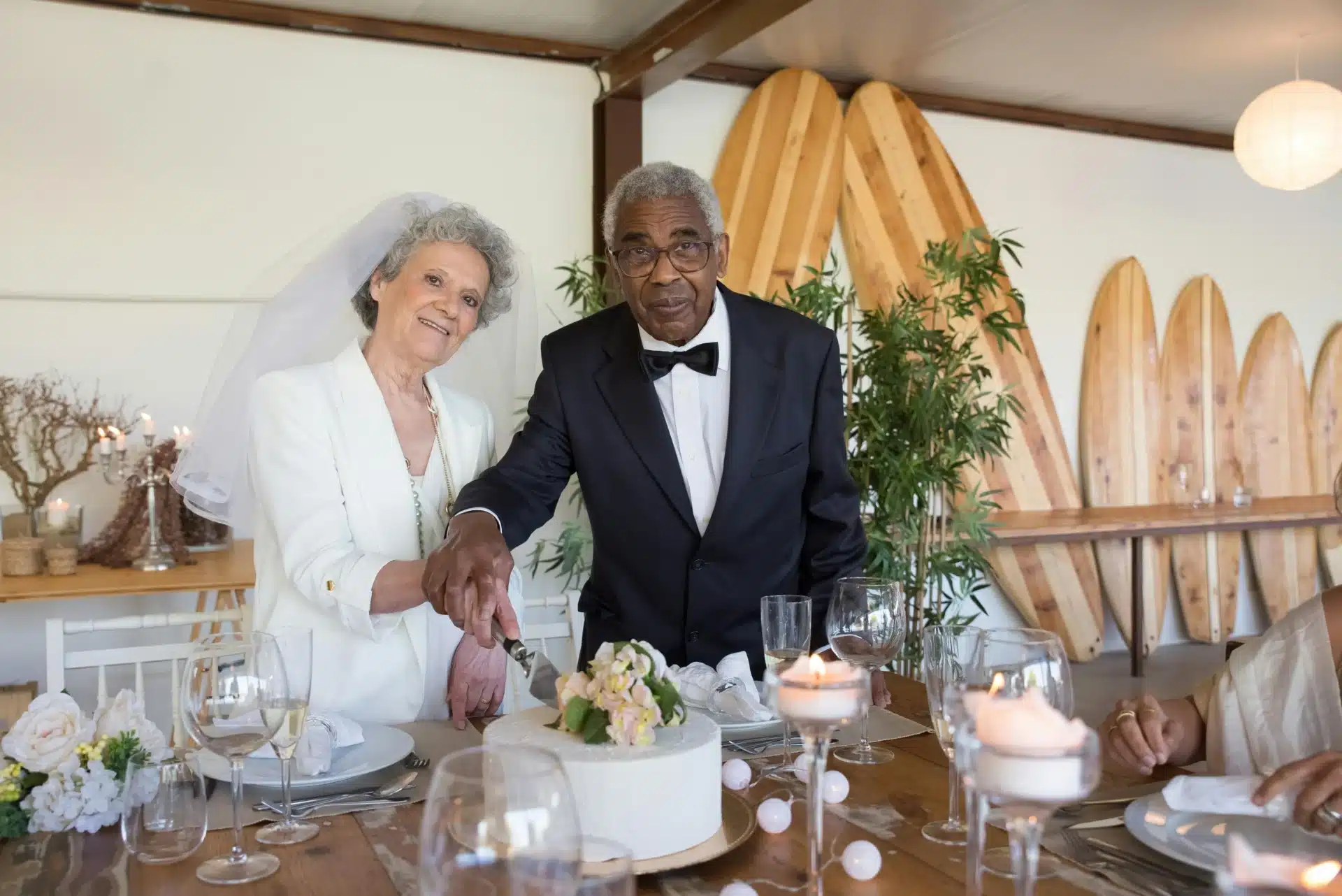 Banquetes elegantes en Bogotá para aniversario de bodas de diamante con esposos mayores cortando el pastel de celebración.