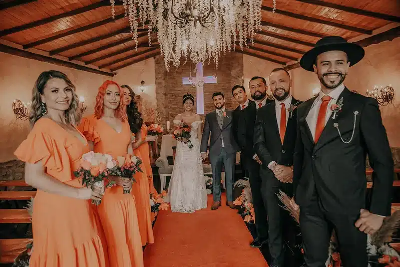 Damas de honor y acompañantes de la novia acompañando a los novios durante la ceremonia de matrimonio en una iglesia elegante.