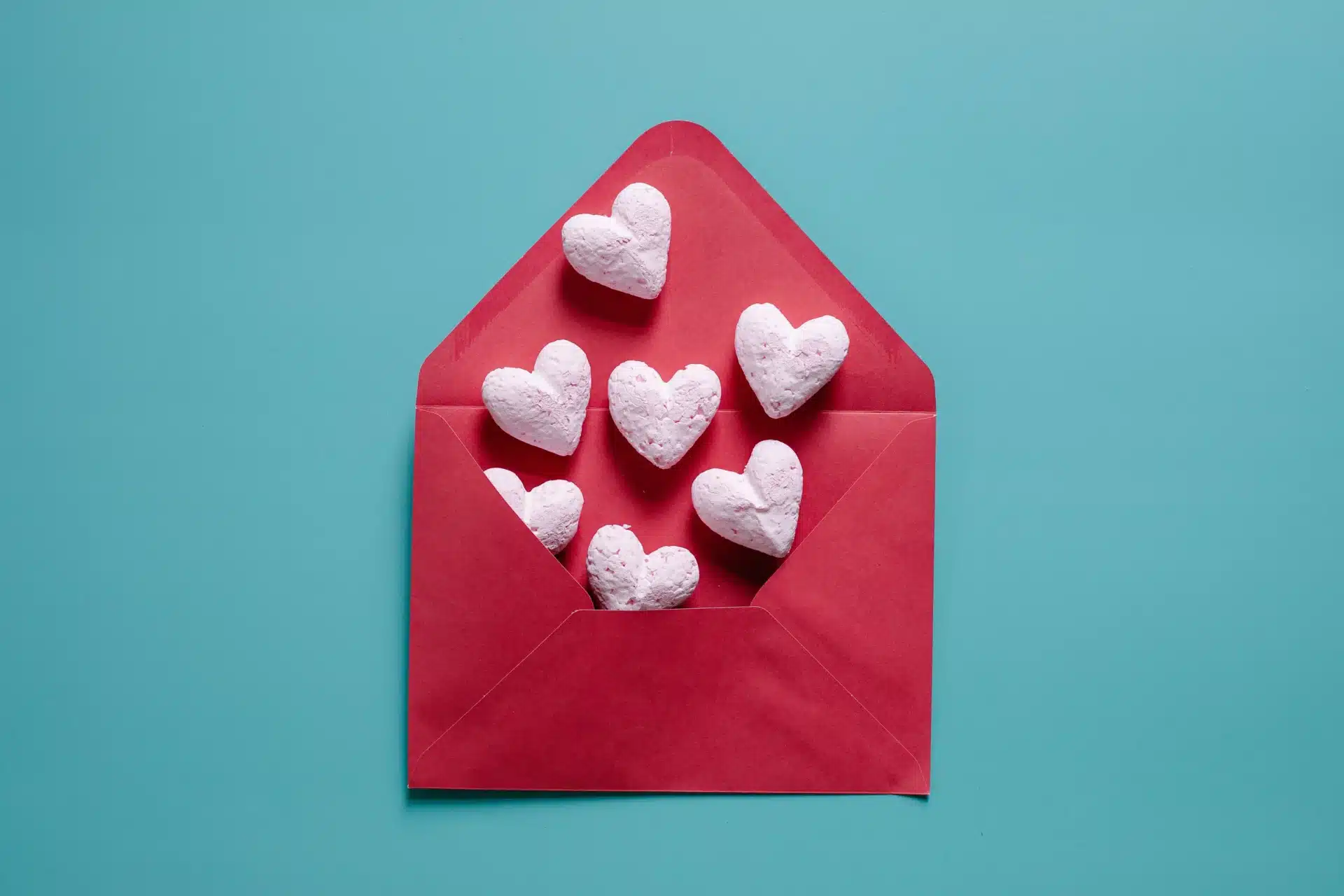 Sobre rojo decorado con corazones, símbolo de amor y mensajes románticos para tu esposo.
