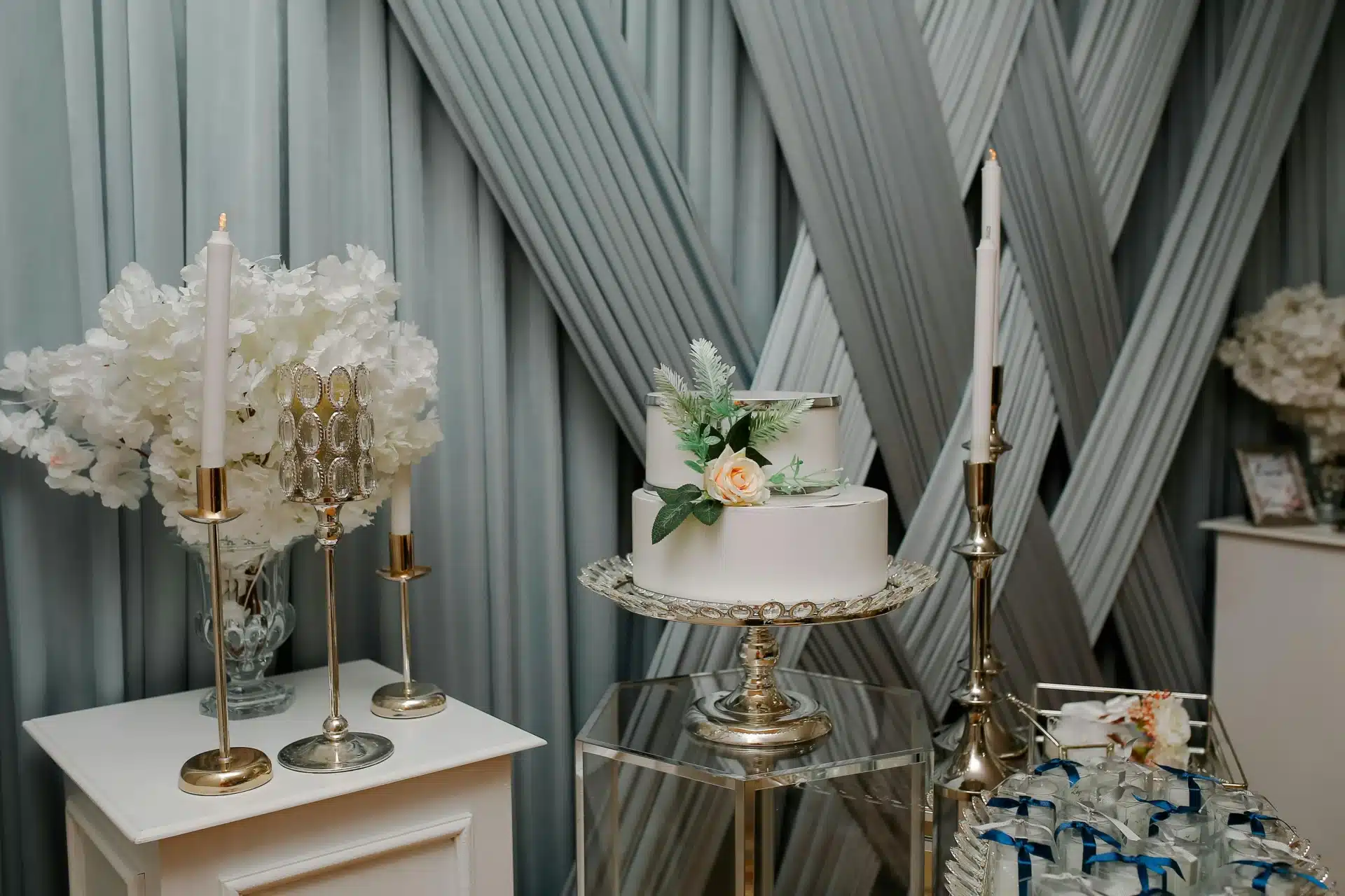 Pasteles de bodas exhibidos en una mesa decorada con flores blancas y detalles sofisticados para una recepción elegante.